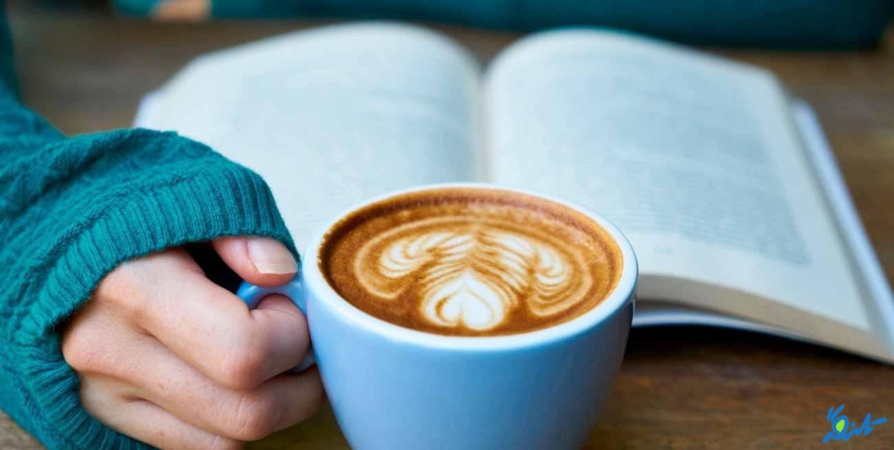 عکس یک فنجان کافه لاته در دستان یک دختر