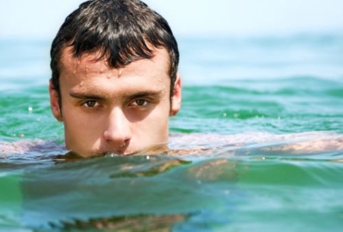 یک مرد در حال شنا کردن در دریا