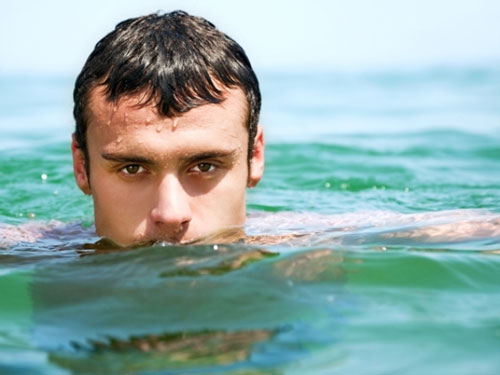 یک مرد در حال شنا کردن در دریا