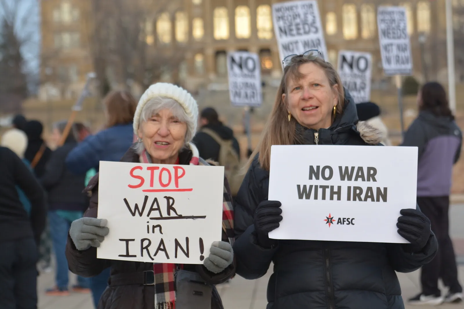 تصویر دو زن امریکایی مخالف جنگ با ایران با پلاکاردهایی در دست