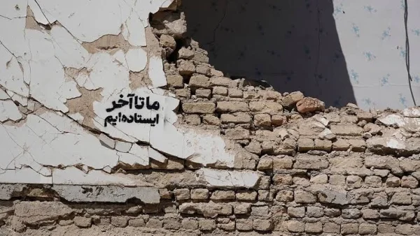 عکس دیواری مخروب که روی آن نوشته شده ما تا آخر ایستاده ایم